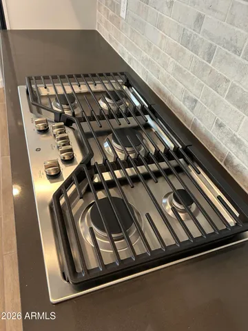 a large kitchen with stainless steel appliances granite countertop a large counter top and a stove top oven with wooden floor