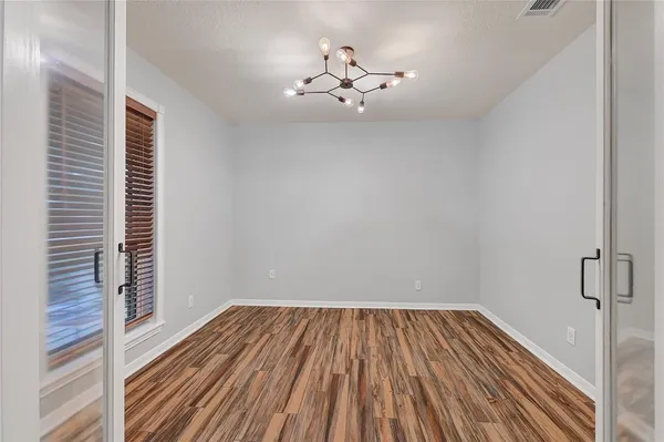 a view of an empty room with glass door and a window