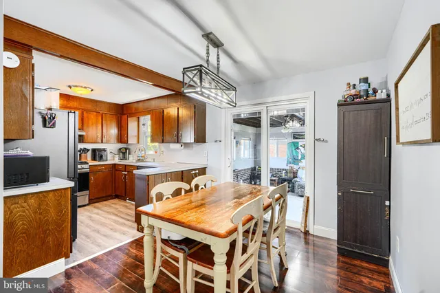 a kitchen with a table chairs refrigerator and microwave