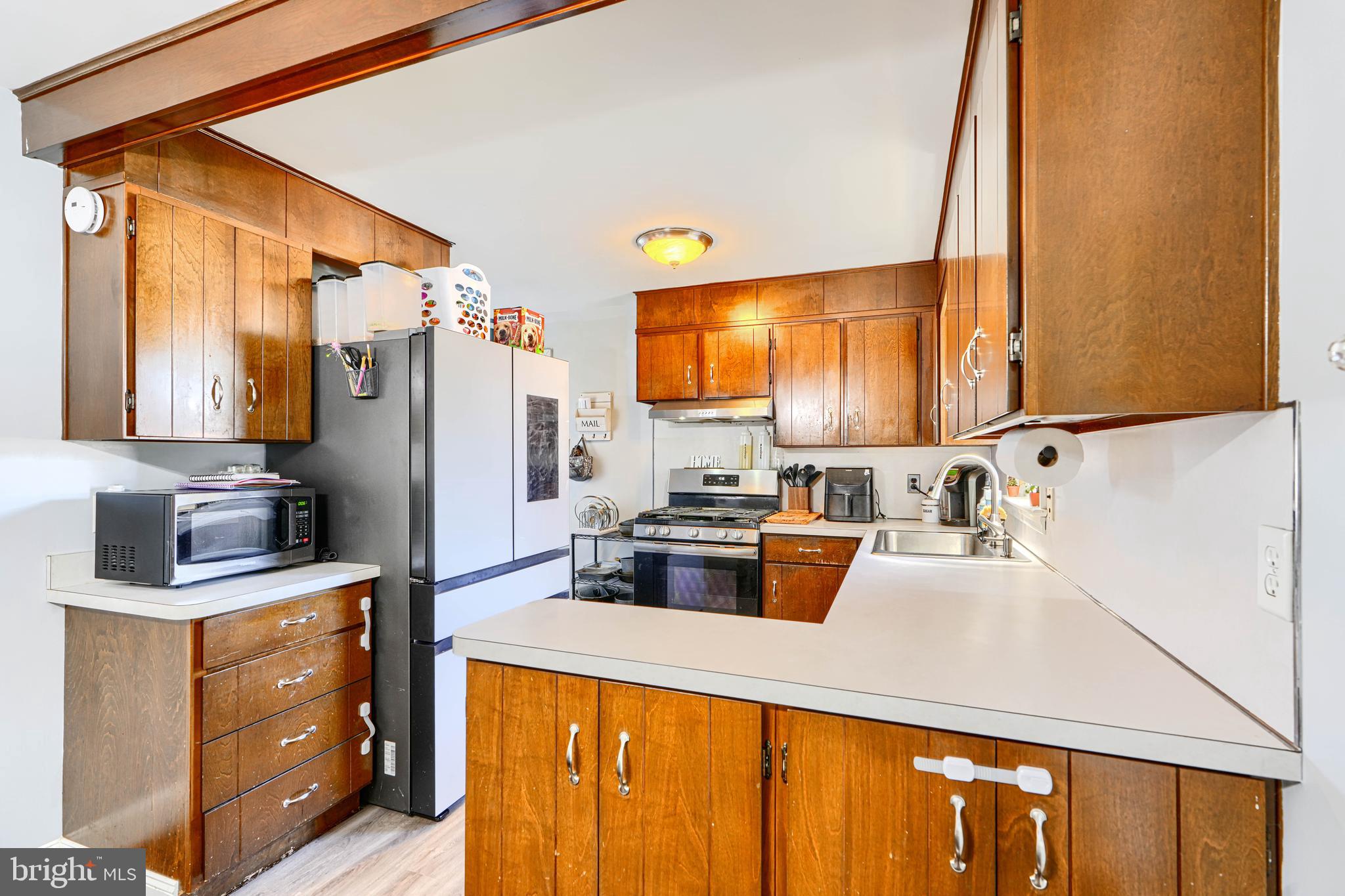 741 South Russell Street York, PA 17402 - Photo 14 of 32 a kitchen with refrigerator a stove a sink dishwasher and wooden cabinets with wooden floor
