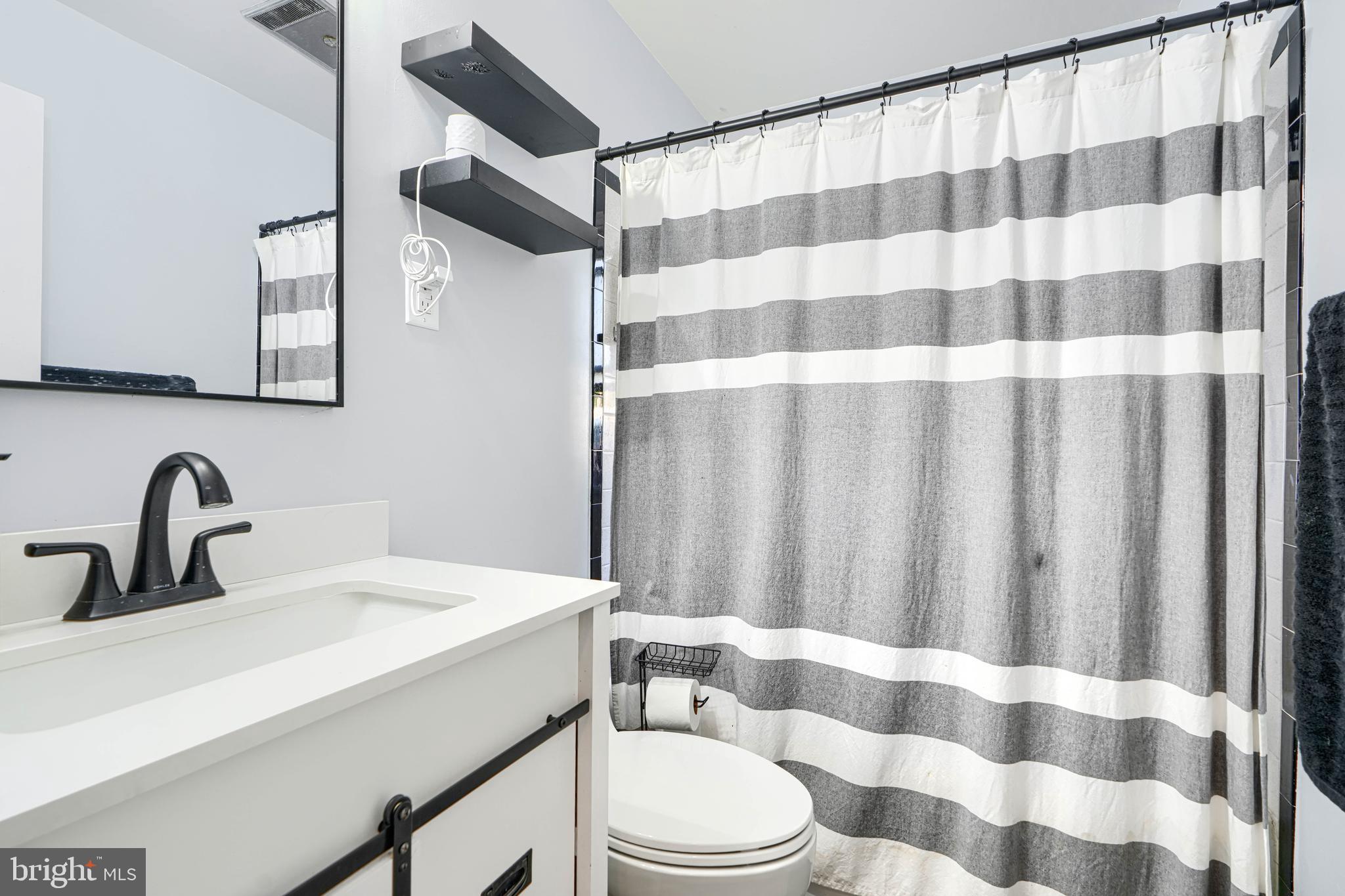 741 South Russell Street York, PA 17402 - Photo 25 of 32 a bathroom with a sink a toilet a mirror and shower curtain