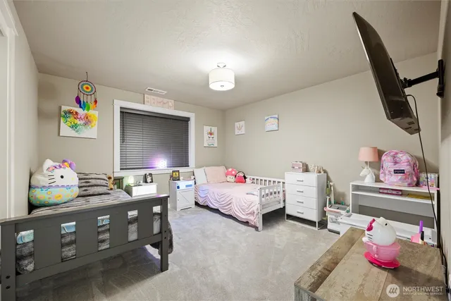 a bedroom with a bed window and a flat screen tv