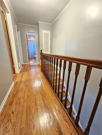 a view of a hallway with wooden floor and staircase