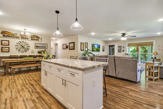 a kitchen with stainless steel appliances granite countertop a stove and a wooden floors