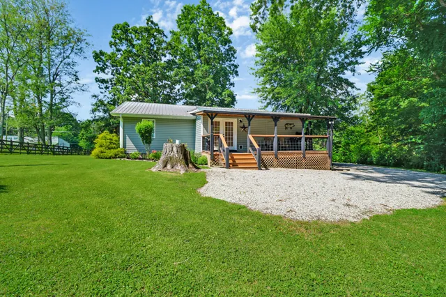 a view of a house with backyard and a tree
