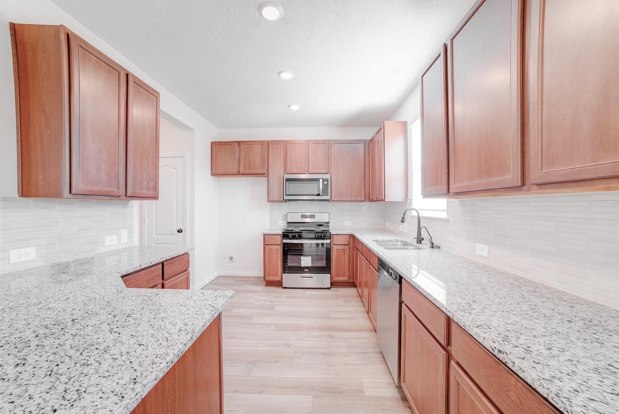 9307 Central Place Magnolia, TX 77354 - Photo 2 of 21 a kitchen with stainless steel appliances granite countertop a sink stove and refrigerator