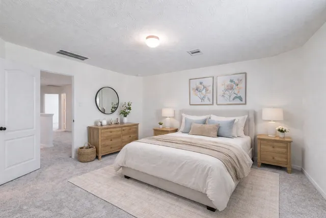 a bedroom with a bed and painting on the wall