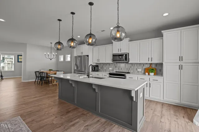a kitchen with kitchen island granite countertop a sink a center island and cabinets