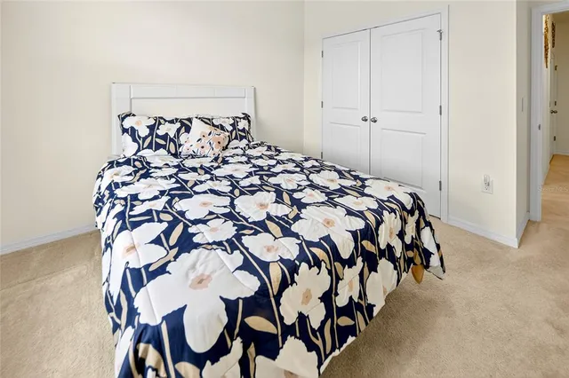 a bed sitting in a bedroom next to a cabinet