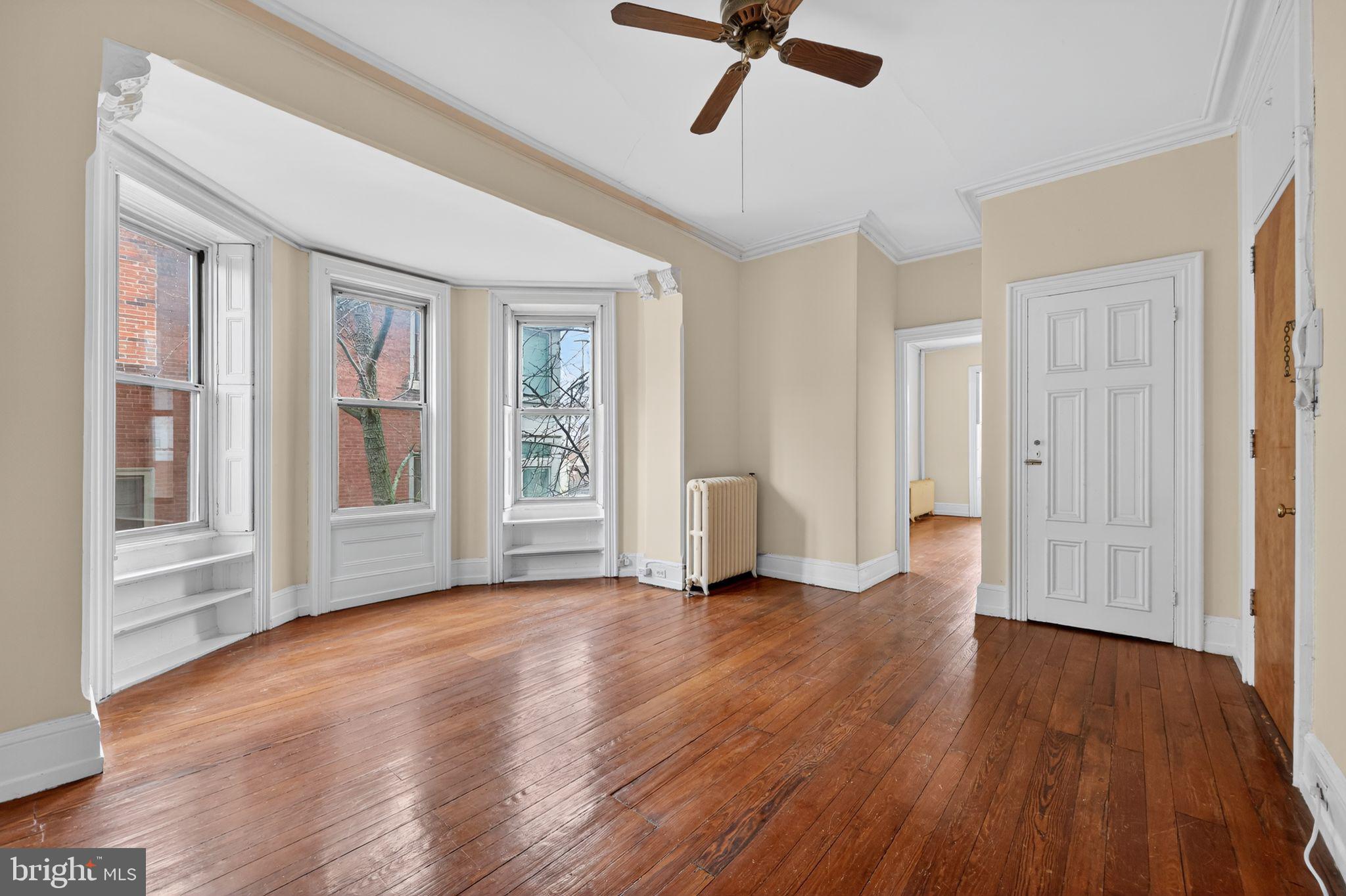 2117 Spruce Street, Unit 3 Philadelphia, PA 19103 - Photo 3 of 14 a view of an empty room with a window and wooden floor