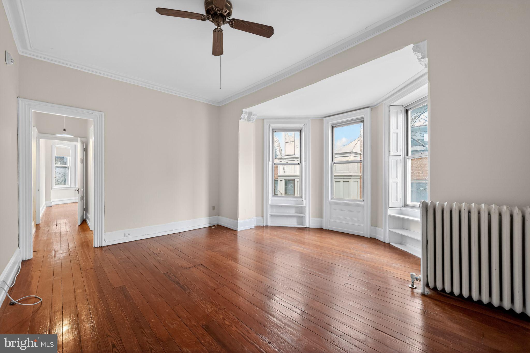 2117 Spruce Street, Unit 3 Philadelphia, PA 19103 - Photo 4 of 14 a view of an empty room with wooden floor and a window