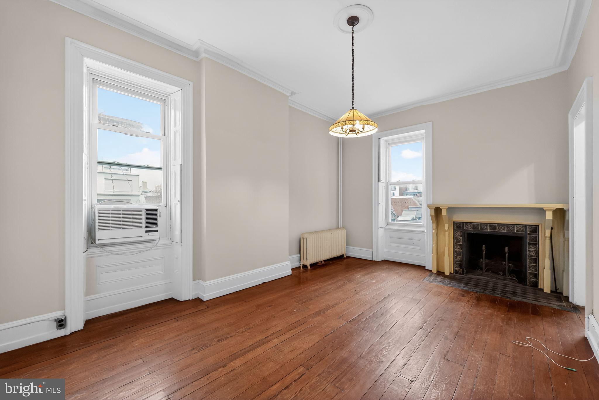 2117 Spruce Street, Unit 3 Philadelphia, PA 19103 - Photo 6 of 14 a view of a room with wooden floor fireplace and window
