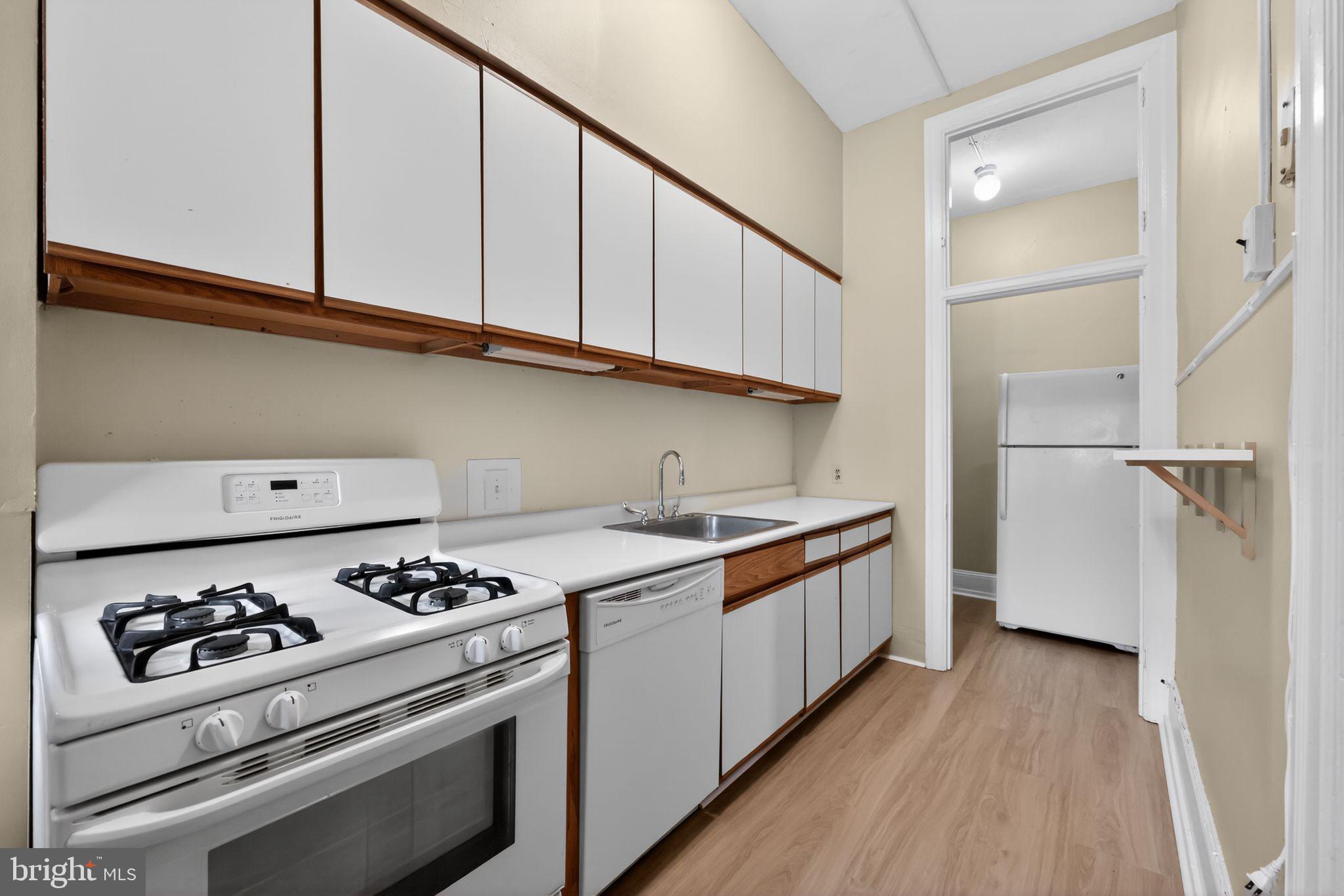 2117 Spruce Street, Unit 3 Philadelphia, PA 19103 - Photo 10 of 14 a kitchen with stainless steel appliances a white stove top oven and sink