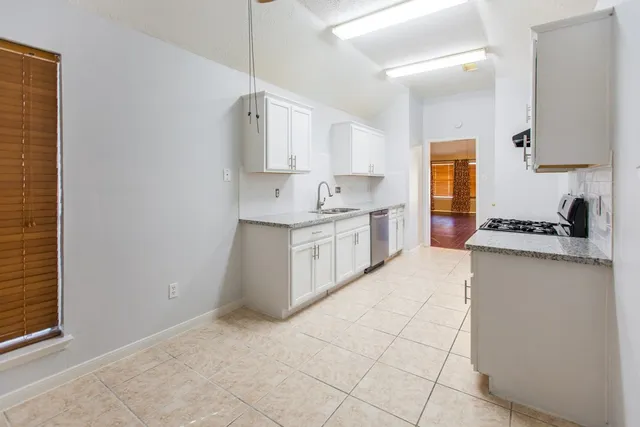 a kitchen with a sink cabinets and a window