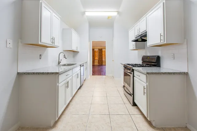 a kitchen with stainless steel appliances granite countertop a stove and a sink