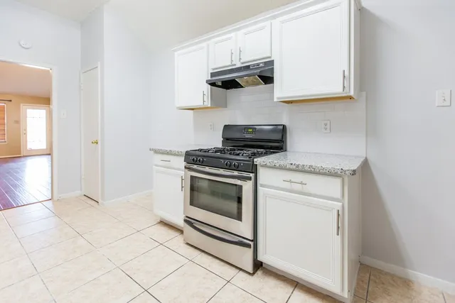 a kitchen with white cabinets and appliances
