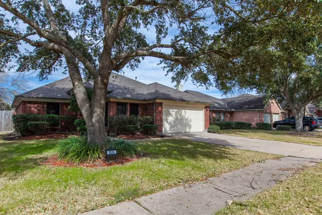 a front view of a house with a garden and trees