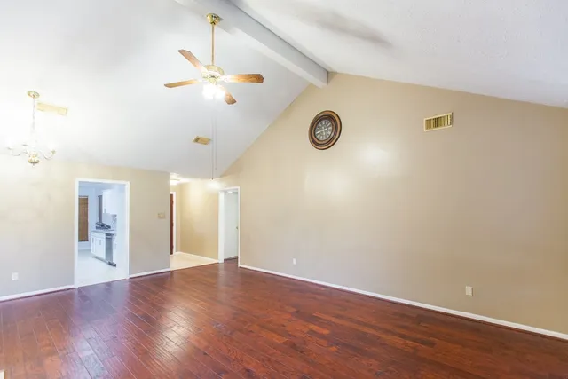a view of an empty room with wooden floor