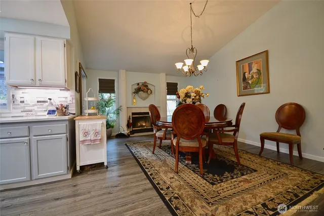 a dining room with furniture a chandelier and wooden floor