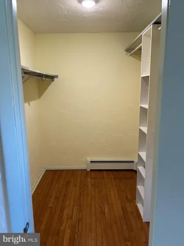 a view of walk in closet with wooden floor