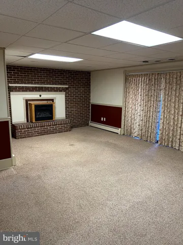 a view of an empty room with a fireplace and a window