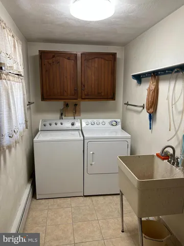 a utility room with dryer washer and a view of living room