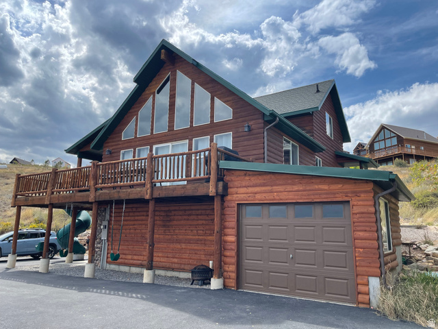 553 Raspberry Patch Road Garden City, UT 84028 - Photo 2 of 21 Back of house featuring faux log siding, a deck, and an attached garage