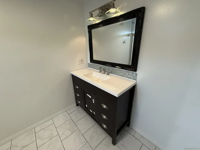 a bathroom with a sink vanity and mirror
