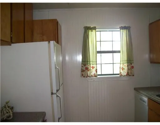 a kitchen with windows and refrigerator