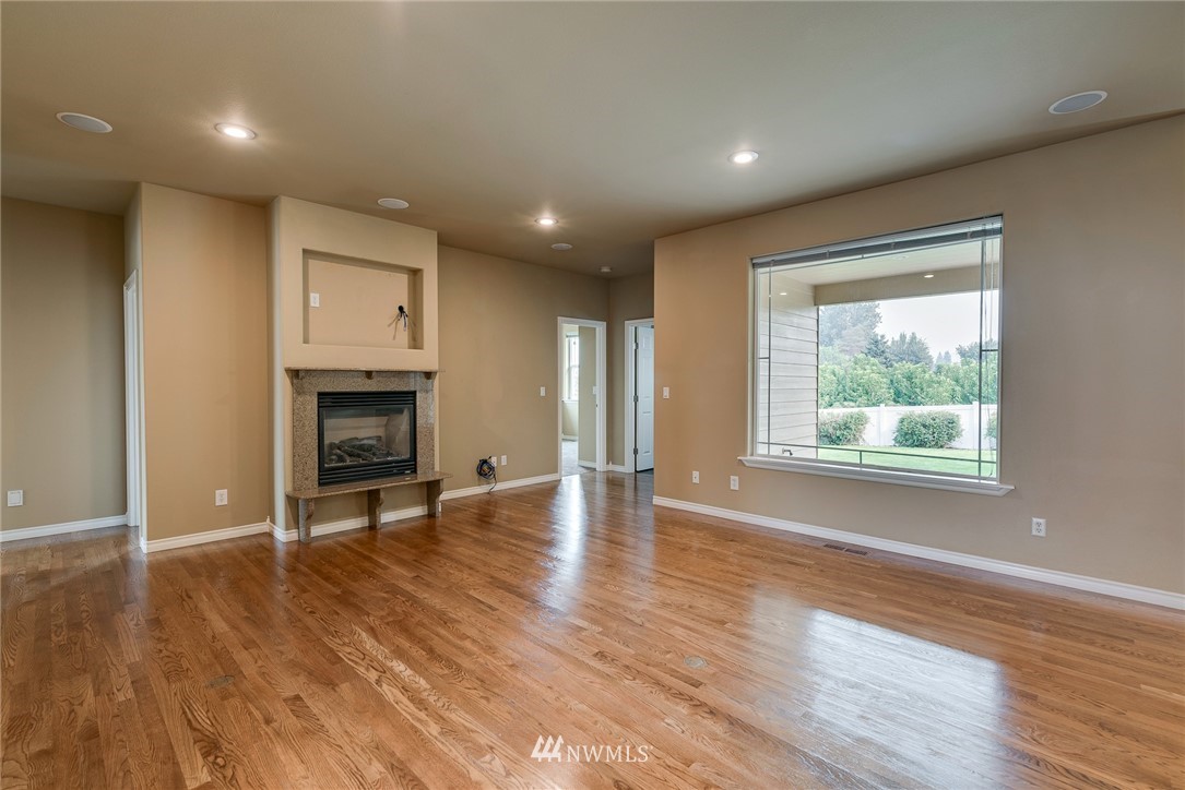 89 Springhill Drive East Wenatchee, WA 98802 - Photo 20 of 36 an empty room with wooden floor fireplace and windows