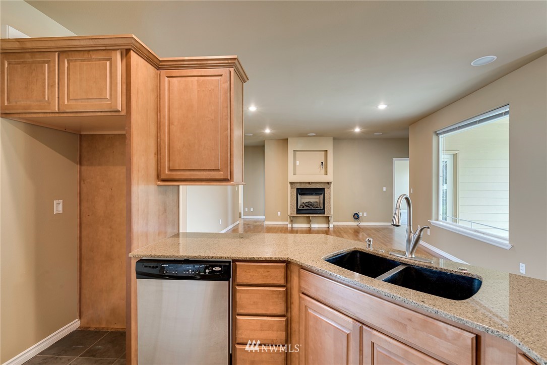 89 Springhill Drive East Wenatchee, WA 98802 - Photo 24 of 36 a kitchen with kitchen island granite countertop a sink and white cabinets