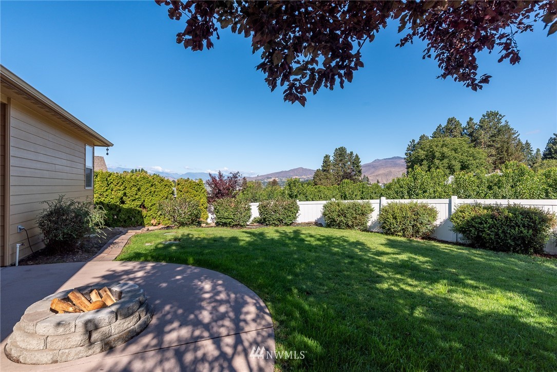 89 Springhill Drive East Wenatchee, WA 98802 - Photo 10 of 36 a view of a backyard with grass and a palm tree
