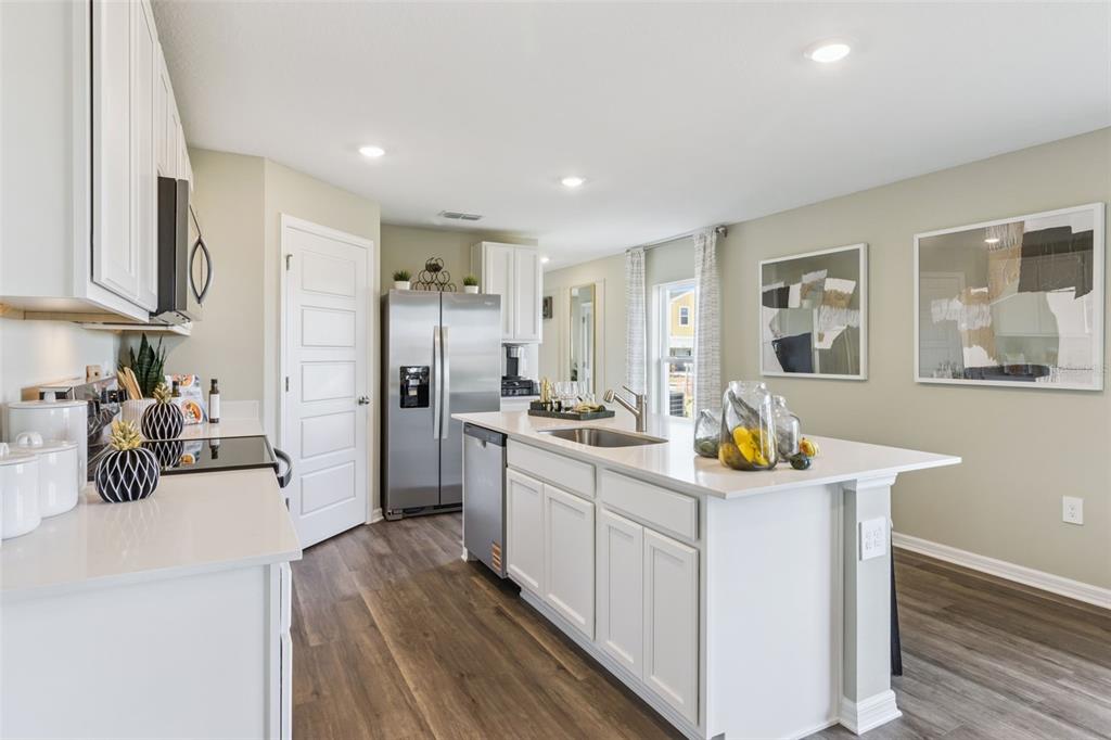 3433 Nettle Loop Tavares, FL 32778 - Photo 4 of 31 a kitchen with sink cabinets and refrigerator