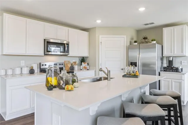 a kitchen with refrigerator and cabinets