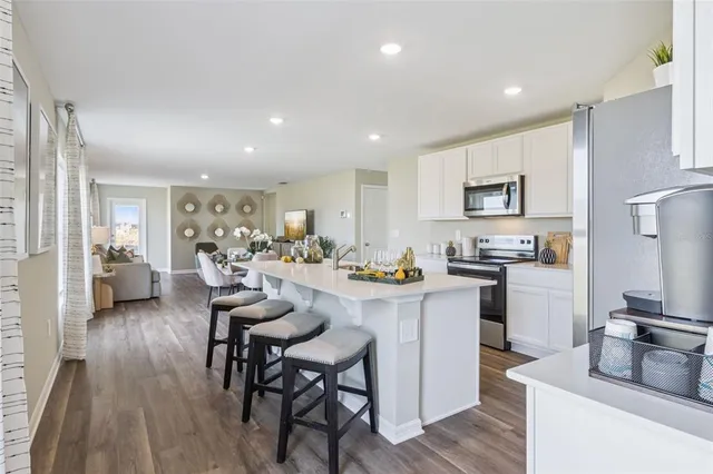 a kitchen with sink a refrigerator and chairs