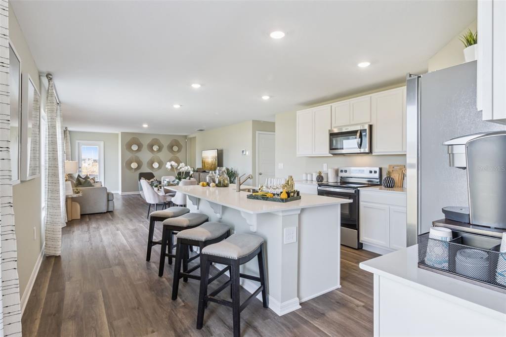 3433 Nettle Loop Tavares, FL 32778 - Photo 7 of 31 a kitchen with sink a refrigerator and chairs