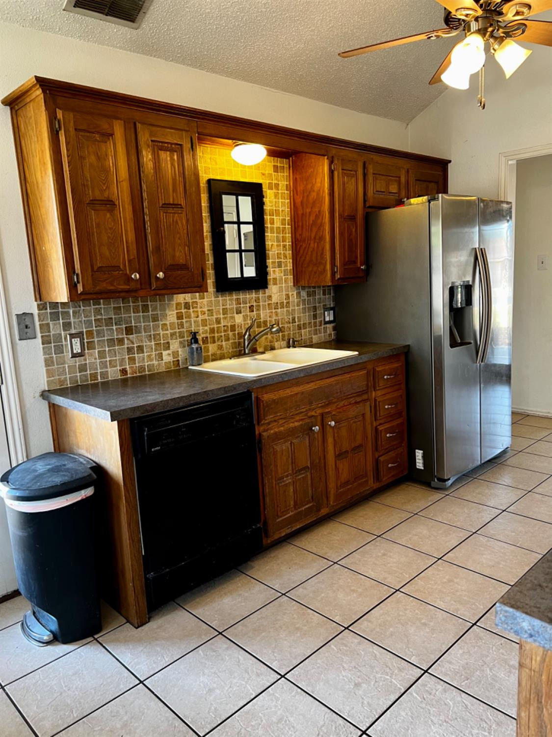 5724 92nd Street Lubbock, TX 79424 - Photo 8 of 18 a kitchen with a sink a stove cabinets and a refrigerator