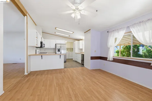 a view of kitchen with wooden floor electronic appliances and window