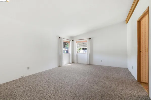 an empty room with windows and closet