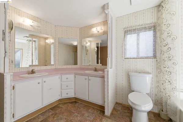 a bathroom with a toilet sink and mirror
