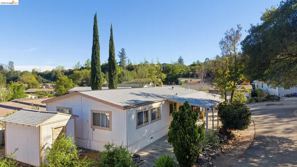 a view of a house with a yard and palm trees