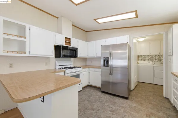 a kitchen with a refrigerator a stove top oven a sink and cabinets