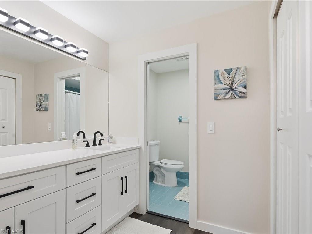 186 Harrison Road, Unit H2 Naples, FL 34112 - Photo 29 of 38 a en suite bathroom with a toilet sink and mirror