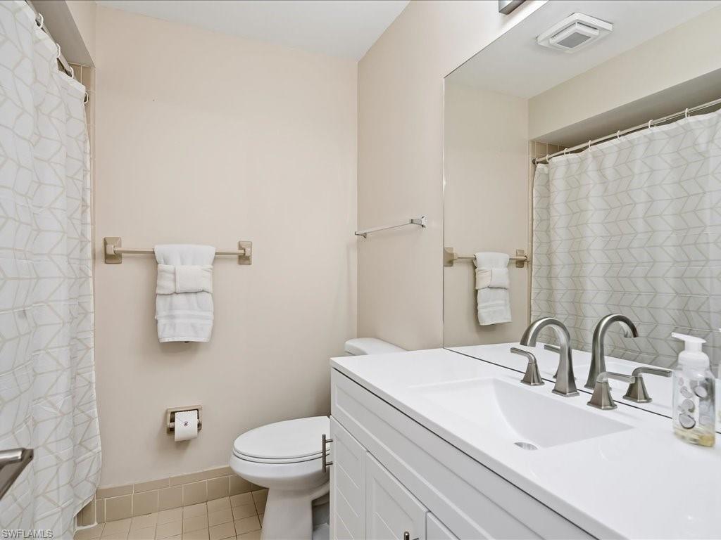 186 Harrison Road, Unit H2 Naples, FL 34112 - Photo 33 of 38 a bathroom with a sink toilet and a mirror