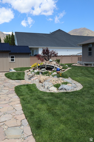 1055 North 1000 East Mapleton, UT 84664 - Photo 86 of 112 Expansive green lawn featuring a stone pathway, decorative rock garden with a small bridge, and established perimeter plantings