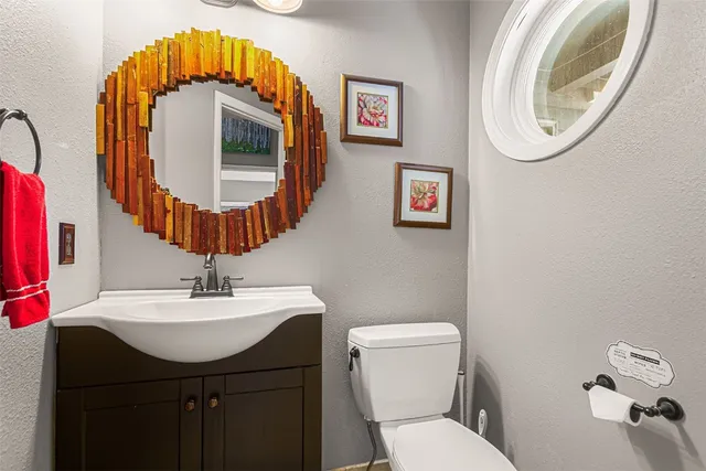 a bathroom with a toilet a sink and a mirror