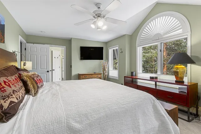 a bedroom with a bed and a large window with a flat screen tv