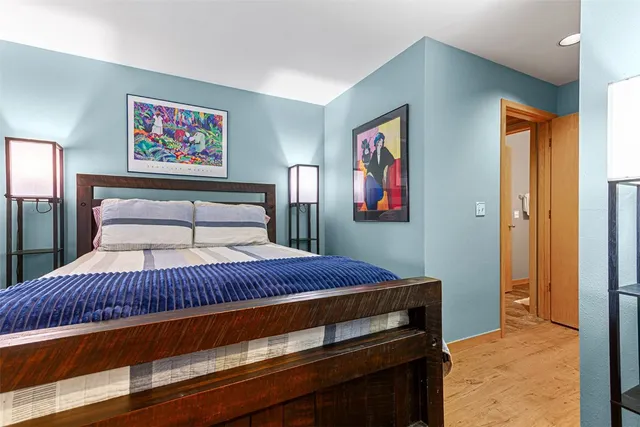 a bedroom with a bed and a painting on the wall