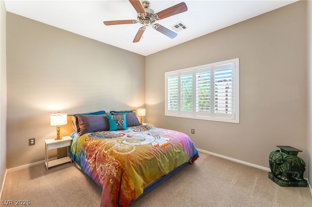 6317 Snap Ridge Street, Unit 101 North Las Vegas, NV 89081 - Photo 13 of 40 Primary suite features shutters, neutral paint, and celing fan.