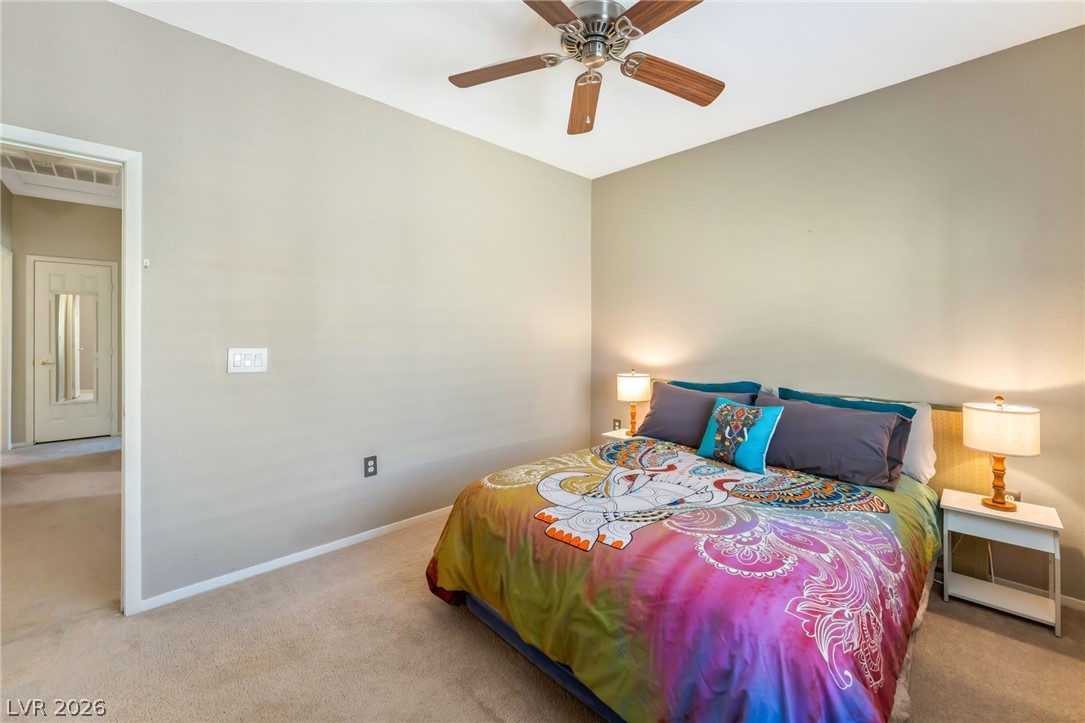 6317 Snap Ridge Street, Unit 101 North Las Vegas, NV 89081 - Photo 14 of 40 Primary suite features shutters, neutral paint, and celing fan.
